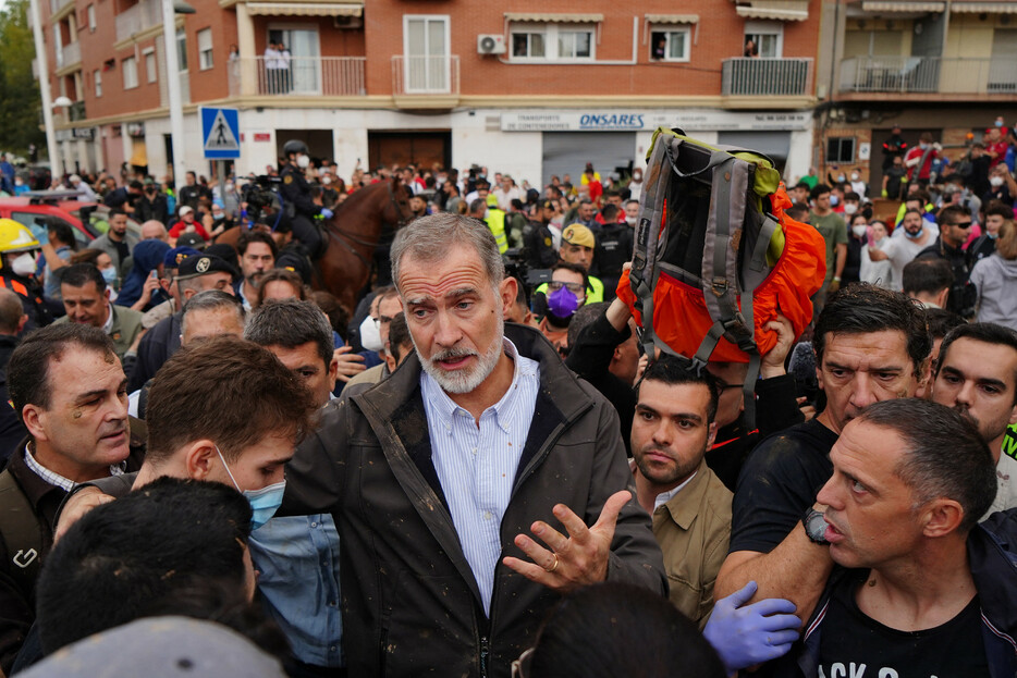 ３日、洪水被害を受けたスペイン東部バレンシア自治州の州都郊外パイポルタを訪れ、住民らと対話するフェリペ国王（中央）。