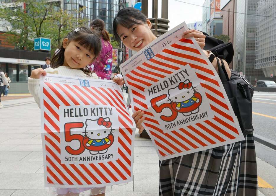 ハローキティ生誕50周年記念号外が配布された＝1日午前、東京都中央区（岩崎叶汰撮影）