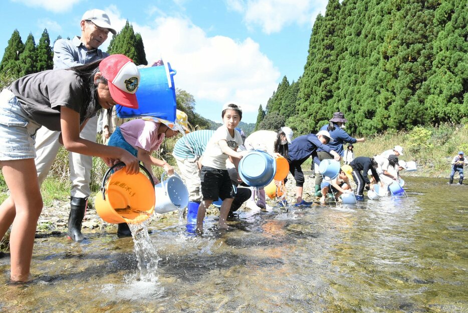 アマゴを放流する沖島小と朽木西小の児童（高島市朽木中牧）