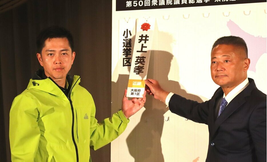 当選確実となった候補者の名前を掲示する維新の馬場代表（右）と吉村共同代表（10月27日）