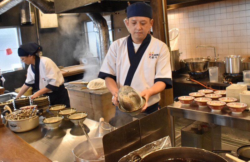 島で栽培した小麦を使ってうどんを作る丸亀製麺の社員＝香川県丸亀市で2024年11月27日午後0時42分、川原聖史撮影