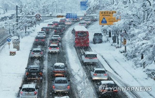 雪道を徐行する車＝28日、水原（聯合ニュース）