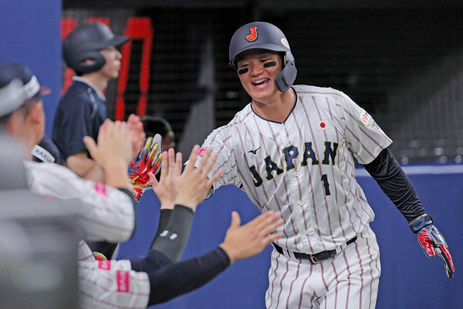 ３回、オーストラリア投手の暴投で生還した日本代表の三塁走者・森下（右）＝１３日、バンテリンドームナゴヤ