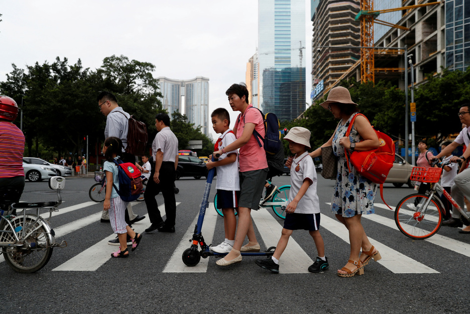 　中国は低迷する経済の活性化を図るため、営利目的の学習塾に対する規制をひそかに緩和しており、３年前の政府による取り締まりで深刻な打撃を受けた業界に復活の兆しが現われている。写真は２０１９年９月、広東省広州市の天河区で学校に向かう子どもらとその親（２０２４年　ロイター/Jorge Silva）