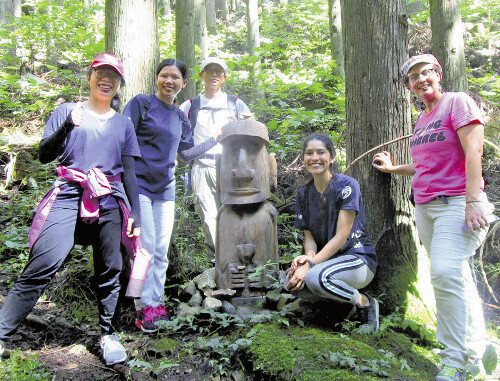 田束山の遊歩道「行者の道」で、海外のボランティア参加者と記念撮影する千葉さん（中央）