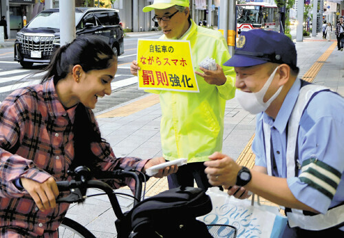 道交法改正についてのビラを配る警察官（１０月２８日、岐阜市で）