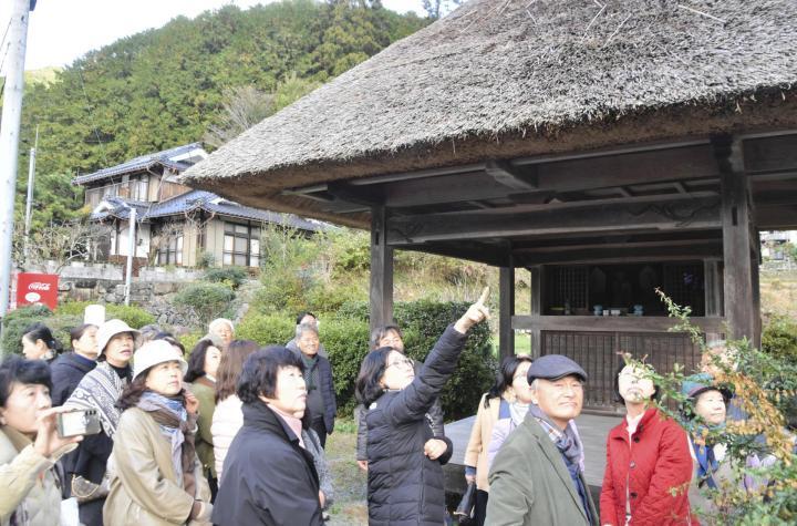 かやぶき屋根の茶堂「沖の堂」を見学する通度寺茶文化大学院の一行＝28日午前、西予市城川町田穂