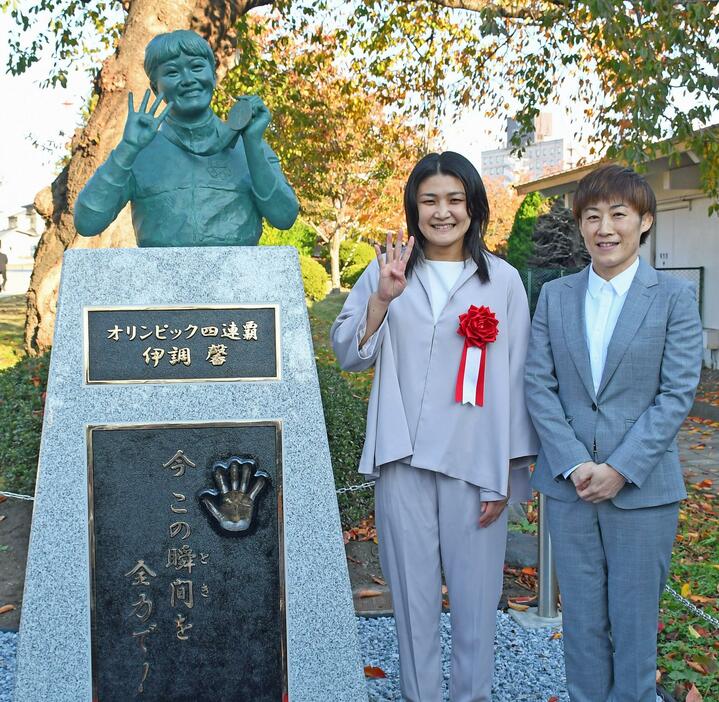 ブロンズ像と同じポーズで笑顔を見せる伊調さんと、姉千春さん