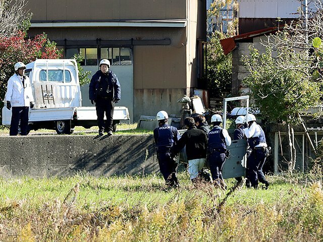 クマ捕獲用のおりを撤去する警察官ら＝２５日午後０時半ごろ、朝日町横尾