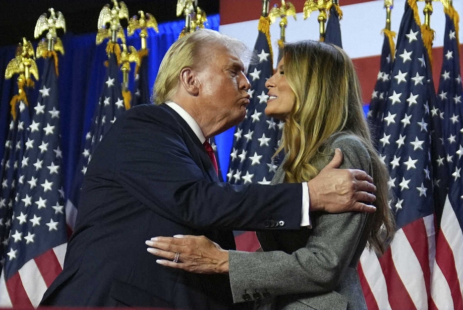 米フロリダ州の集会会場で妻のメラニアさん（右）にキスをするトランプ前大統領