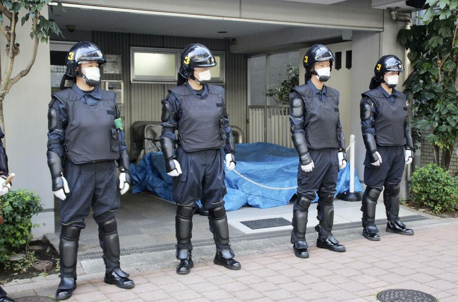 家宅捜索に入った革マル派関係先のマンション前で警戒に当たる警視庁の機動隊員＝12日午前、東京都新宿区