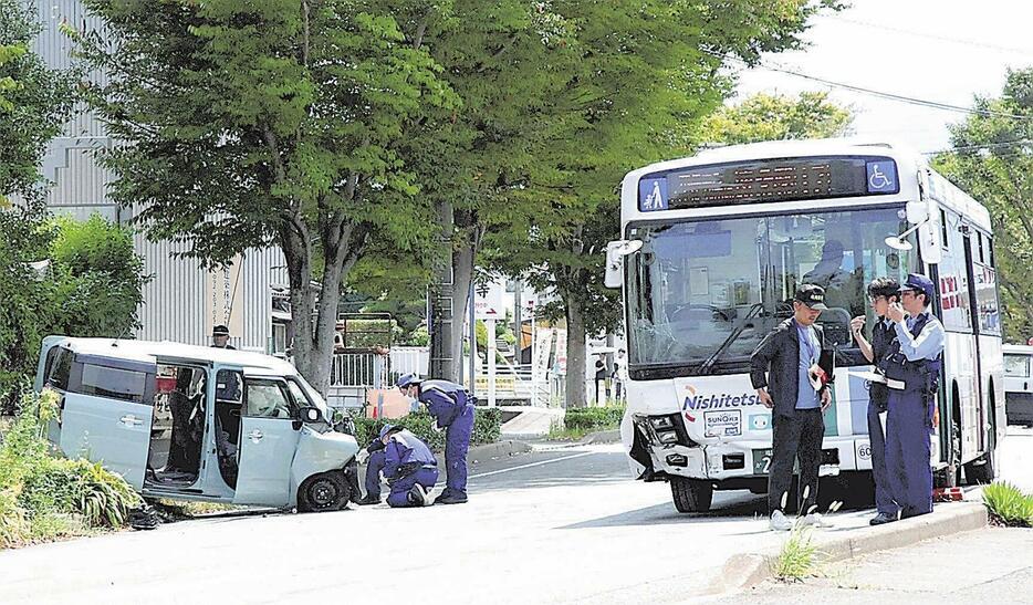 軽乗用車がバスと衝突した現場を調べる警察官ら（8月18日、福岡市早良区で）