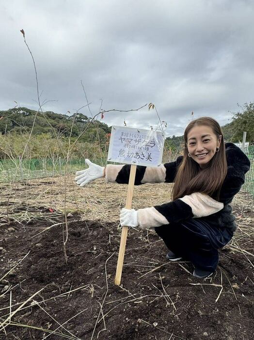 ヤマザクラの苗木を植樹し、笑顔を見せる熊切あさ美