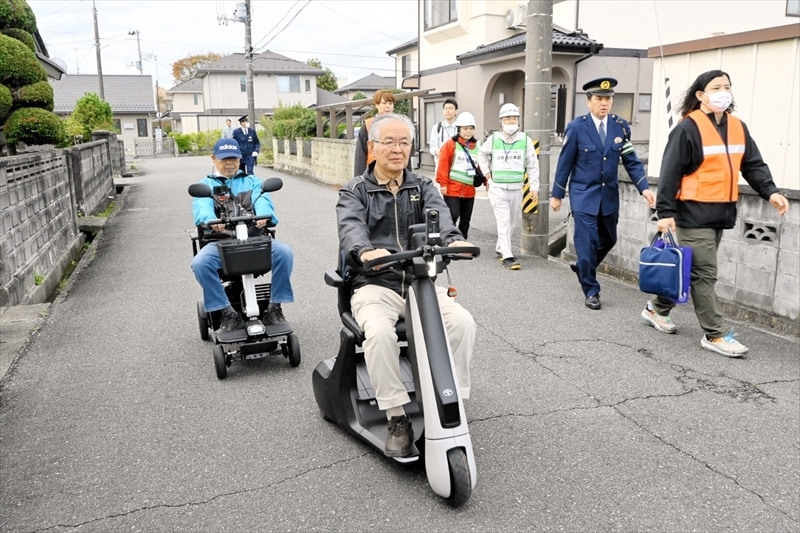 電動小型モビリティーに乗って避難する訓練参加者