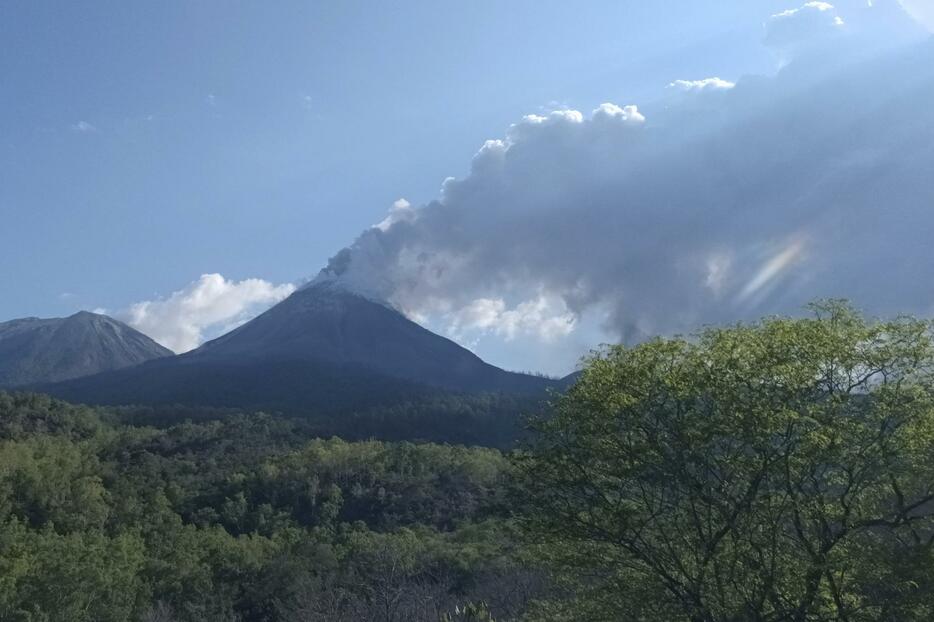 13日、インドネシア東部フロレス島で噴煙を上げる山（AP＝共同）