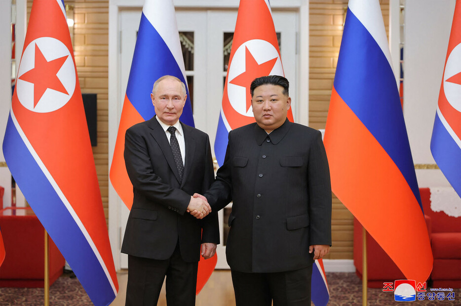 ロシアのプーチン大統領（左）と握手する北朝鮮の金正恩朝鮮労働党総書記＝６月１９日、平壌（ＡＦＰ時事）