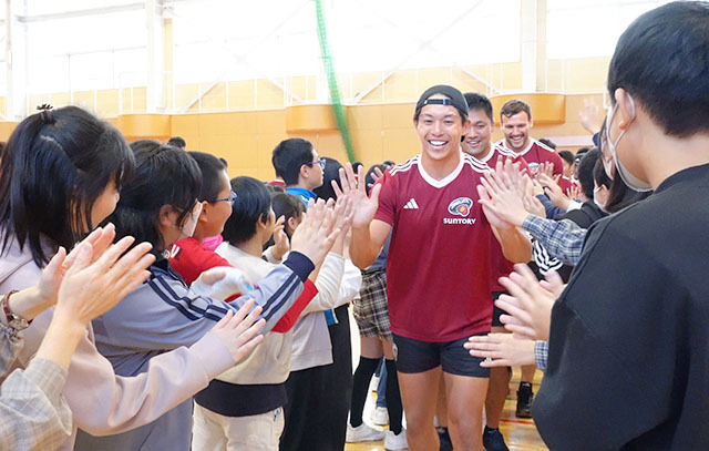 児童とハイタッチするラグビーのトップアスリートたち＝山形市・山形二小