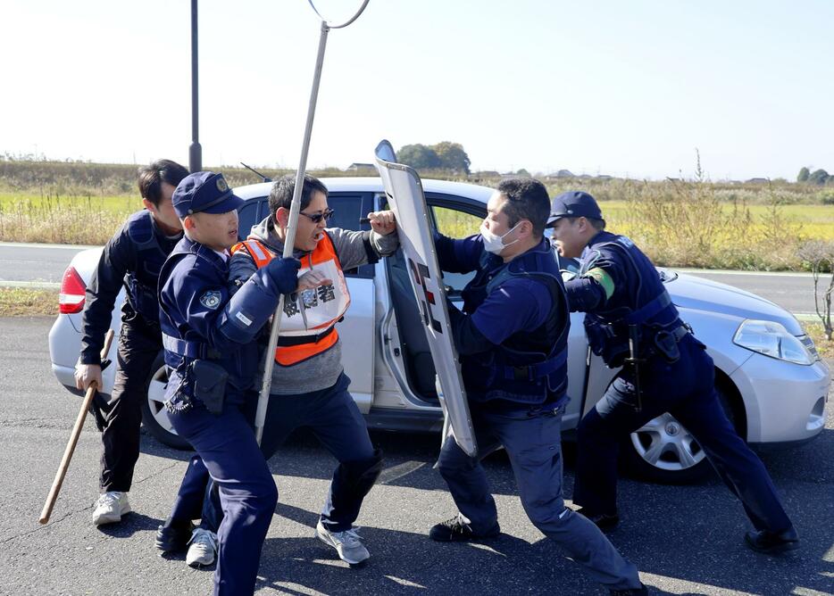 群馬、茨城、栃木の3県警が行った訓練で、犯人役（中央）を取り押さえる警察官＝12日午前、群馬県板倉町