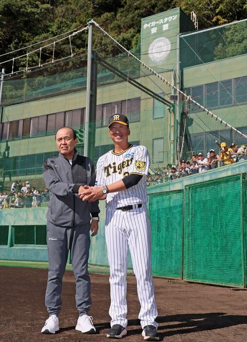 岡田顧問（左）を迎える藤川監督。師弟コンビがガッチリと握手した