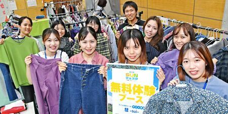 ４回目の「０円マーケット」を開いた琉球大４年の饒平名凜さん（手前右から２人目）ら「子ども服屋　彗」のメンバーとボランティア＝３日、南風原町新川・環境の杜ふれあい