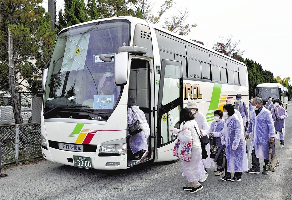 避難先に向かうため、バスに乗り込む訓練参加者（鳥取県米子市で）