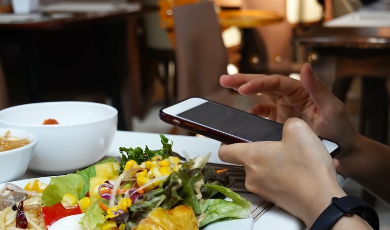 スマホを見ながらランチタイム。一般的な風景になったが…（写真はイメージ/gettyimages)