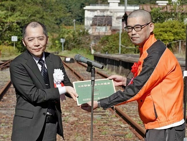 西山哲支部長から銘板を受け取る宮崎大輔所長（右）＝島根県川本町川本、旧ＪＲ三江線石見川本駅