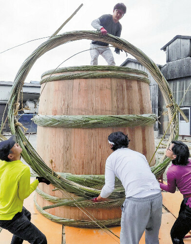 巨大な木桶作りでタガを入れる職人たち（１０月２７日、川島町で）＝鈴木竜三撮影