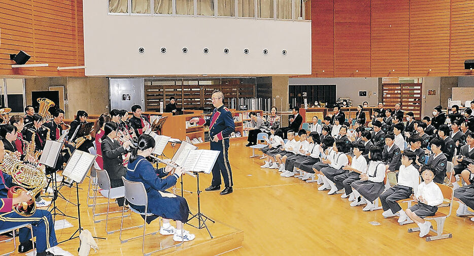 演奏を披露する県警音楽隊と吹奏楽部の生徒。児童は手拍子しながら聞いた＝輪島市門前中