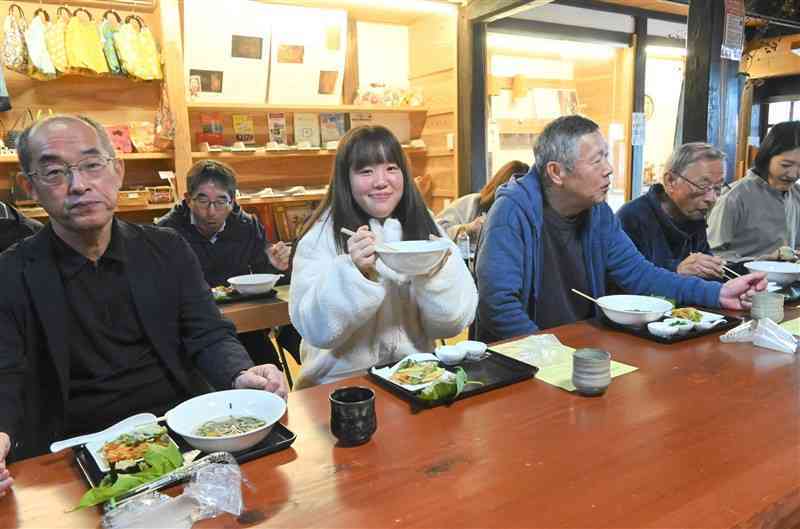 桑の葉うどんを試食する発案者の廣崎穂乃花さん（中央）＝24日、山鹿市