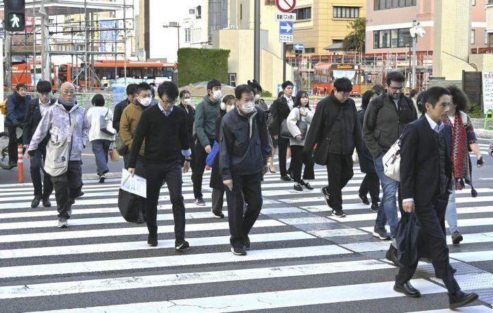 冷え込みが厳しくなった朝、厚手の服装で通勤する人たち＝19日午前8時ごろ、松山市湊町4丁目（撮影・松本尚也）