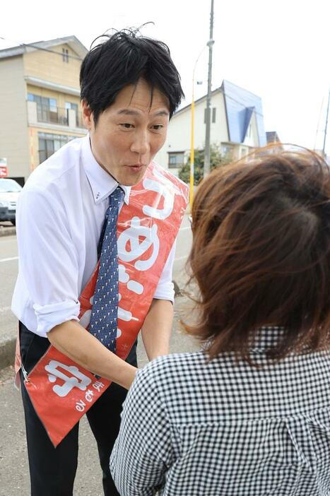 有権者と握手をする梅谷守氏＝１０月１５日、妙高市