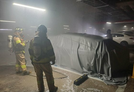 火事が起こった電気自動車を窒息消火砲で覆った消防隊員たち。［写真　忠清南道牙山消防署］