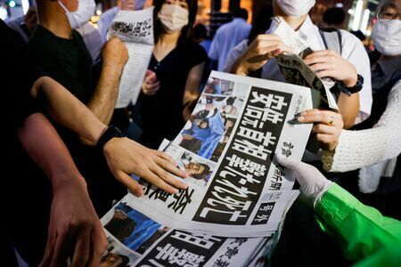 新聞の号外を手に取る人たち（写真：ロイター/アフロ）