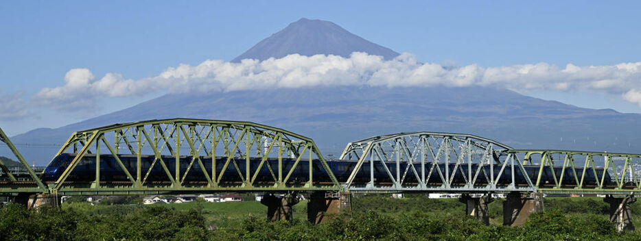 雄大な富士山を背に、富士川に架かる橋を通過するザ・ロイヤルエクスプレス＝8日午後2時ごろ、富士市