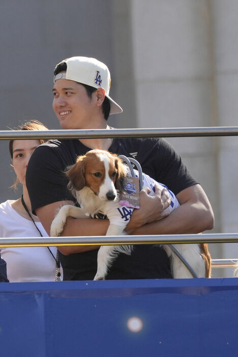 真美子さん（後方）と一緒に愛犬・デコピンを抱いてパレードを楽しむ大谷翔平（ＡＰ）