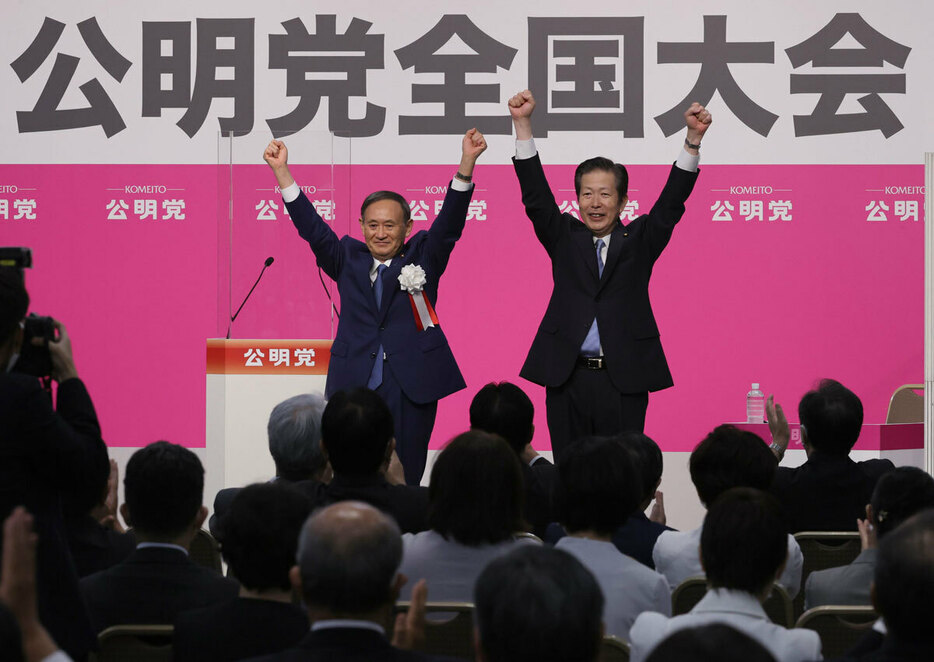 公明党大会で山口那津男代表（右）と両手を上げる菅義偉首相＝2020年9月