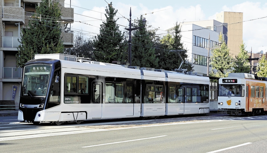 試乗会で走行する熊本市電の新型車両「2400形」（左）（23日、熊本市中央区で）＝秋月正樹撮影