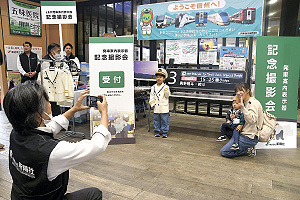 LCD発車標の前で記念撮影する親子連れ