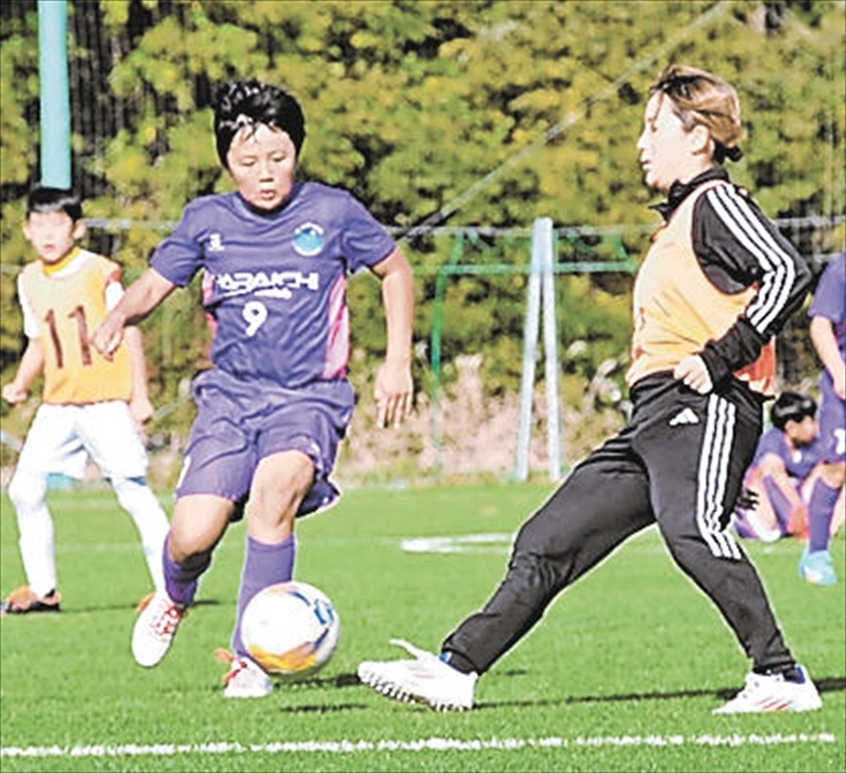 サッカー教室で子どもたちと一緒にプレーする岩渕さん（右）