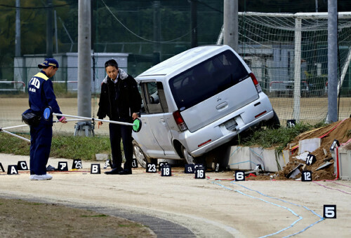 事故車両を調べる捜査員ら（１７日午前６時５８分、埼玉栄高校グラウンドで）