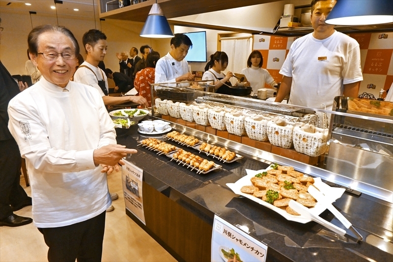 川俣シャモを使った料理を紹介する藤原町長（左）