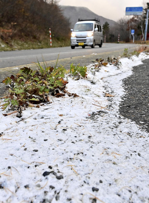 うっすらと雪が積もった国道115号＝19日午前7時ごろ、福島市土湯温泉町