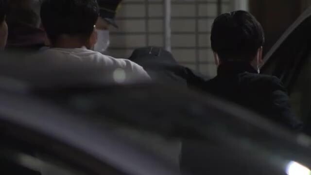 警察署に移送される２４歳男（画面中央）