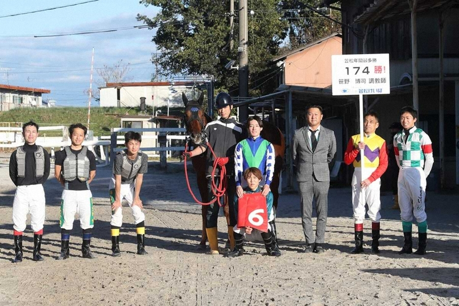 関係者と記念撮影を行う笹野博司調教師（右から3人目、岐阜県地方競馬組合提供）