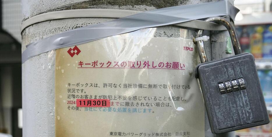 電柱に設置されたキーボックスと、撤去を命じる警告文＝27日午後、東京都中央区（書類送検された男性のボックスとは別物です）