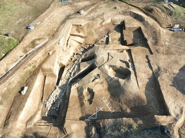 伽耶里遺跡の土城城壁と城内の狭く窪んだ谷間地から城外に流れる石垣排水路の跡を上から見下ろした様子＝国立伽耶文化遺産研究所提供