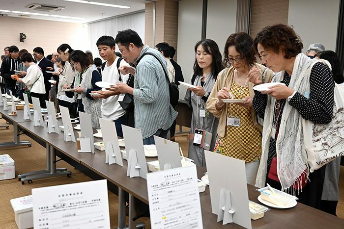 出品された豆腐を試食する参加者ら＝9日、那覇市の県市町村自治会館