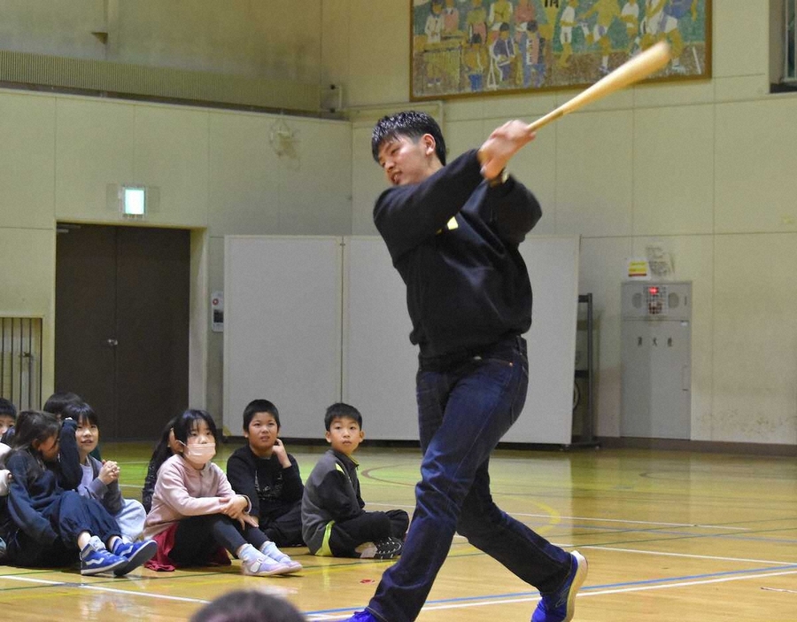 子供たちの前でスイングを披露する野村（中央）