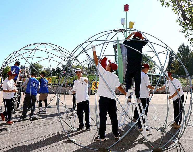 球体ドームにLEDを取り付ける参加者=砺波市の砺波チューリップ公園